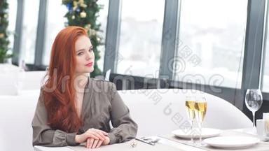 迷人的红发女孩在冬天在一家豪华餐馆等她的男朋友